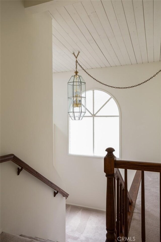 stairway featuring carpet floors and an inviting chandelier