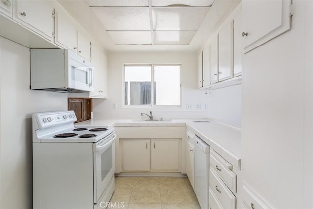 kitchen featuring sink, white appliances, and white cabinets