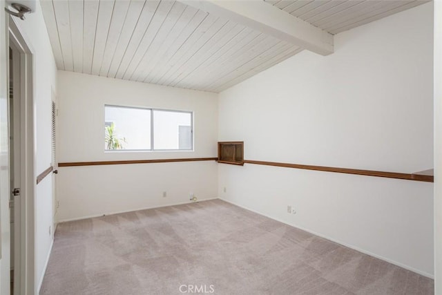 carpeted spare room with vaulted ceiling with beams