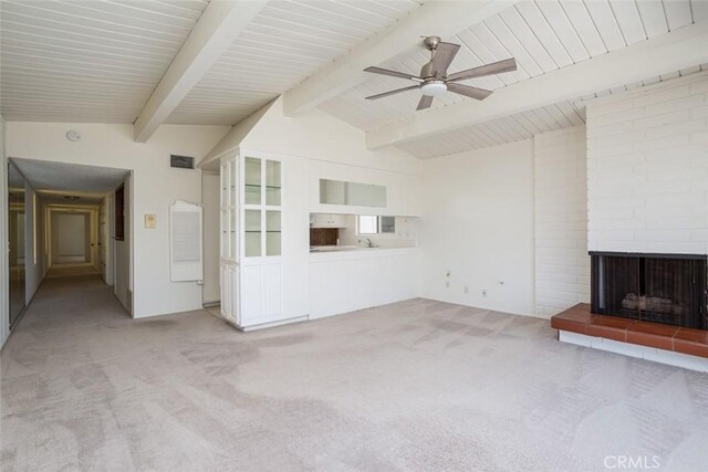 unfurnished living room with ceiling fan, carpet floors, a fireplace, vaulted ceiling with beams, and sink