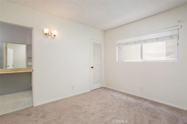 carpeted spare room with a textured ceiling