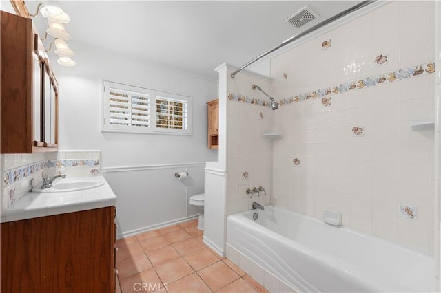 full bathroom featuring toilet, tiled shower / bath combo, tile patterned floors, and vanity