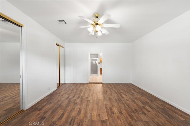 empty room featuring ceiling fan and dark hardwood / wood-style floors