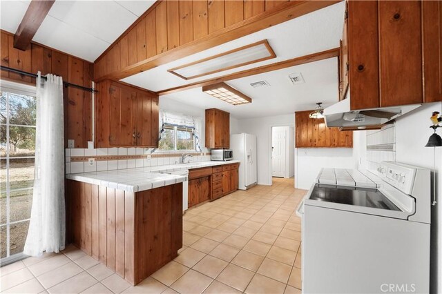 40836 36th St W, Palmdale, CA 93551 - kitchen featuring washer / dryer, white appliances, under cabinet range hood, brown cabinets, and tile countertops