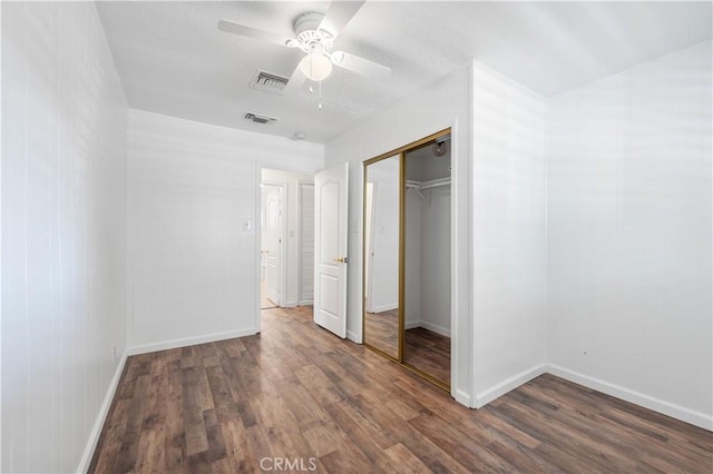 unfurnished bedroom featuring ceiling fan, a closet, and dark hardwood / wood-style flooring