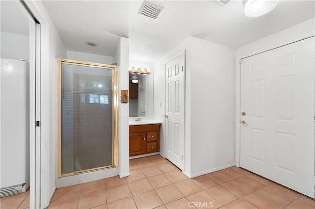 bathroom featuring tile patterned floors, walk in shower, and vanity