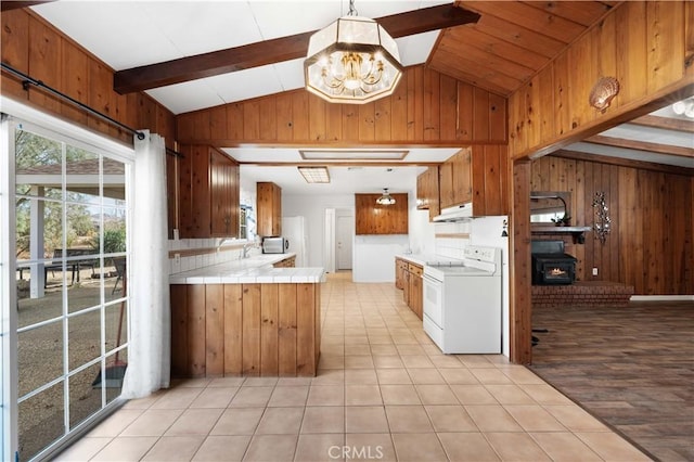 kitchen featuring light tile patterned floors, white electric range oven, wooden walls, and an inviting chandelier