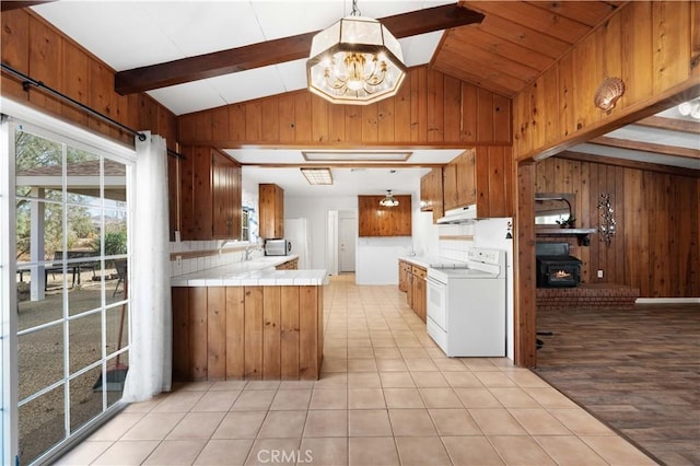 40836 36th St W, Palmdale, CA 93551 - kitchen with white range with electric cooktop, under cabinet range hood, wood walls, a chandelier, and tile counters