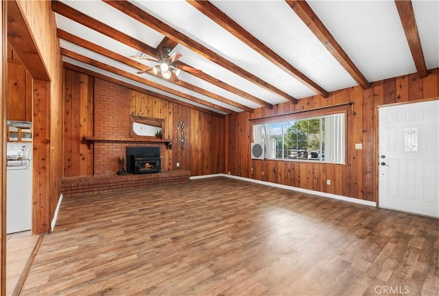 unfurnished living room featuring ceiling fan, washer / clothes dryer, hardwood / wood-style flooring, and vaulted ceiling with beams