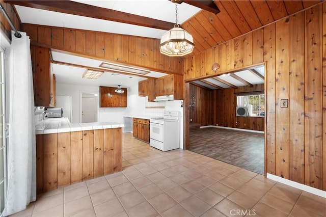 kitchen featuring kitchen peninsula, wood walls, tile counters, tasteful backsplash, and white range with electric cooktop