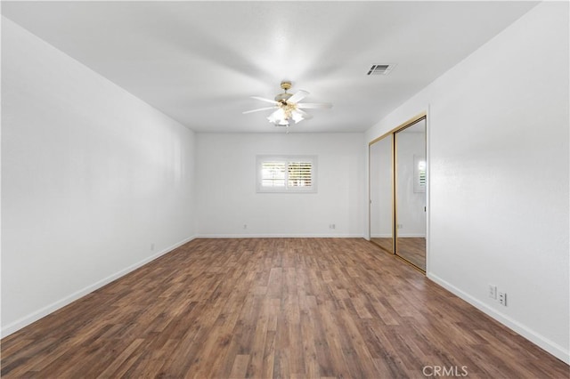 spare room with ceiling fan and dark wood-type flooring