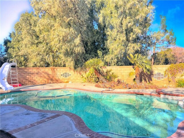 40836 36th St W, Palmdale, CA 93551 - view of swimming pool with a water slide, a fenced backyard, and a pool with connected hot tub
