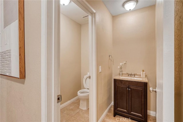 bathroom with toilet, vanity, and tile patterned flooring