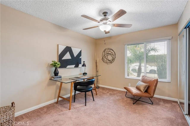 carpeted office featuring ceiling fan and a textured ceiling