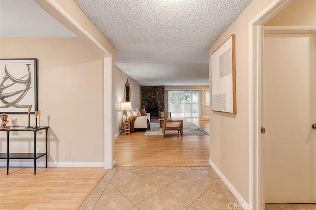 hallway featuring a textured ceiling and light tile patterned flooring