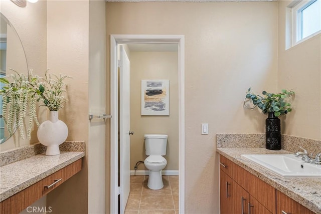 bathroom with toilet, vanity, and tile patterned floors