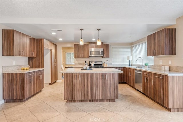 kitchen featuring decorative light fixtures, a center island, sink, light tile patterned flooring, and appliances with stainless steel finishes