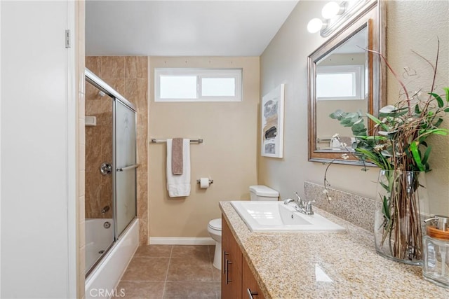 full bathroom with toilet, bath / shower combo with glass door, a healthy amount of sunlight, and tile patterned floors