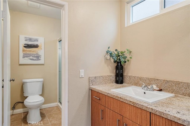 bathroom featuring toilet, vanity, tile patterned floors, and walk in shower