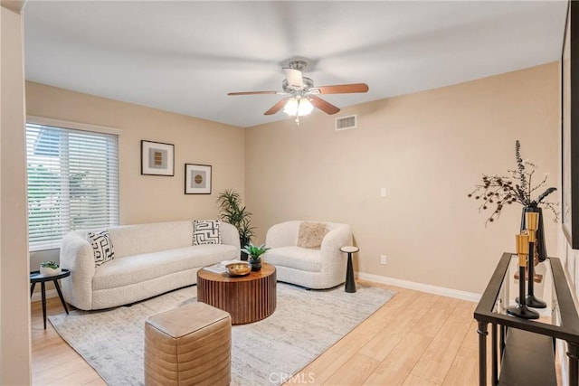 living room with ceiling fan and light hardwood / wood-style flooring