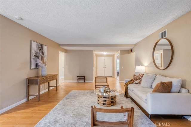 living room featuring a textured ceiling and light hardwood / wood-style flooring