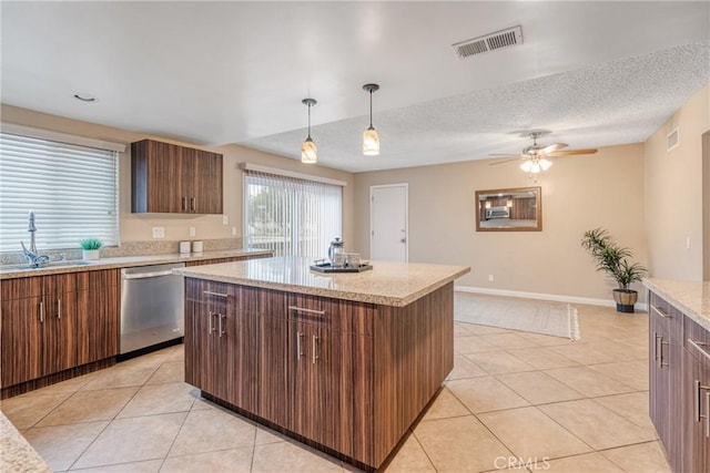 kitchen featuring light tile patterned flooring, dishwasher, a center island, and sink