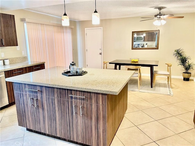 kitchen with decorative light fixtures, light tile patterned floors, stainless steel appliances, and a kitchen island