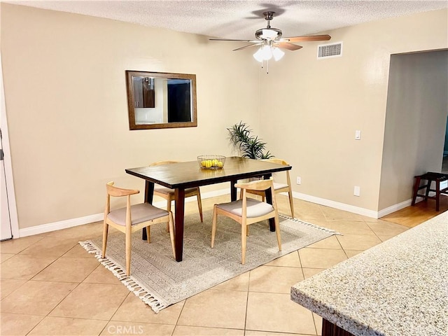 dining area featuring ceiling fan, light tile patterned floors, and a textured ceiling