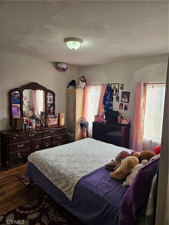 bedroom with dark wood-type flooring