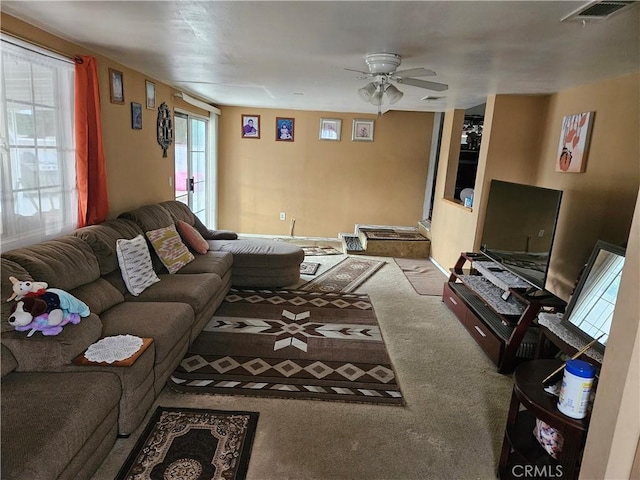 carpeted living room with ceiling fan