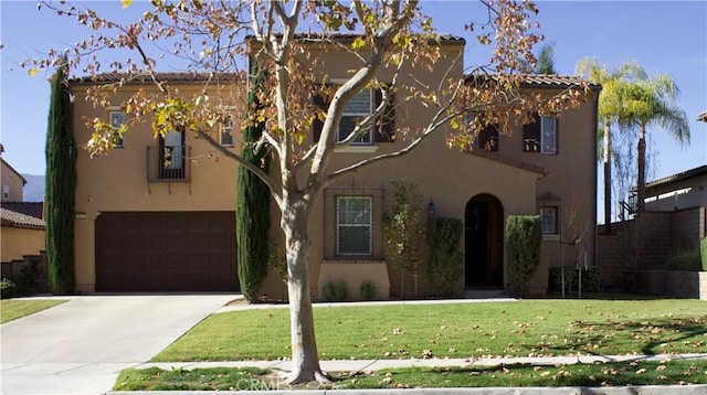 mediterranean / spanish-style home with a front yard and a garage