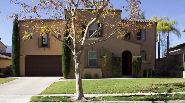 mediterranean / spanish home featuring a garage and a front yard