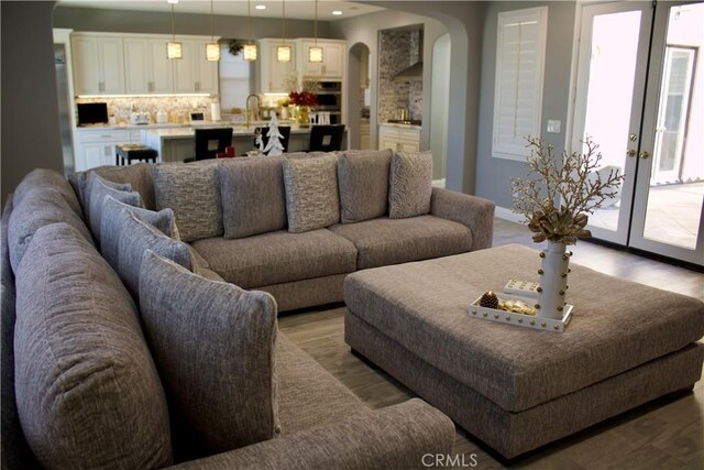 living room with hardwood / wood-style floors and sink