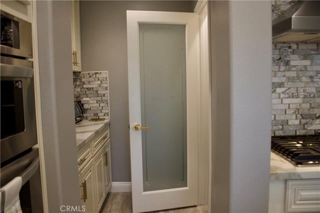 bathroom featuring vanity, backsplash, and wood-type flooring