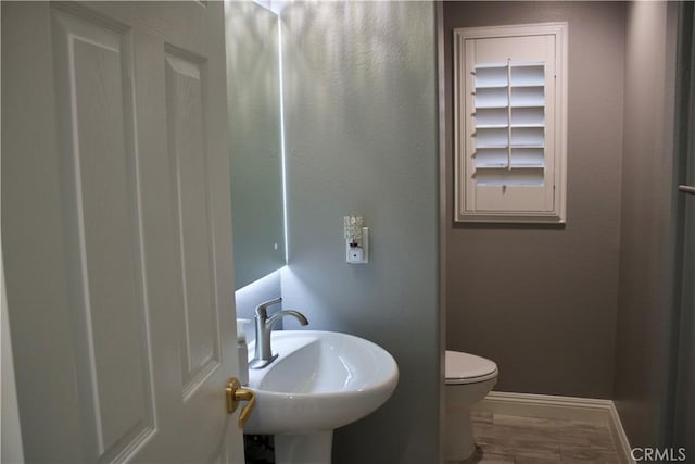 bathroom with hardwood / wood-style flooring, sink, and toilet