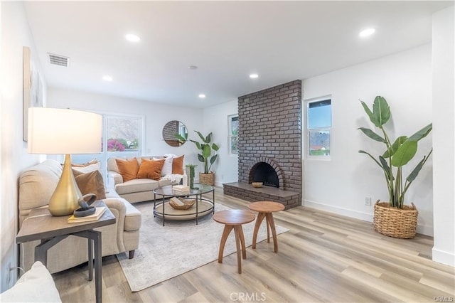 living room with light hardwood / wood-style floors and a fireplace