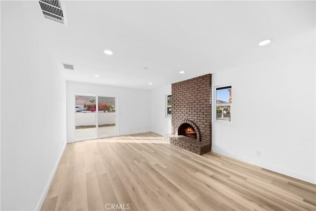 unfurnished living room featuring light wood-type flooring and a fireplace