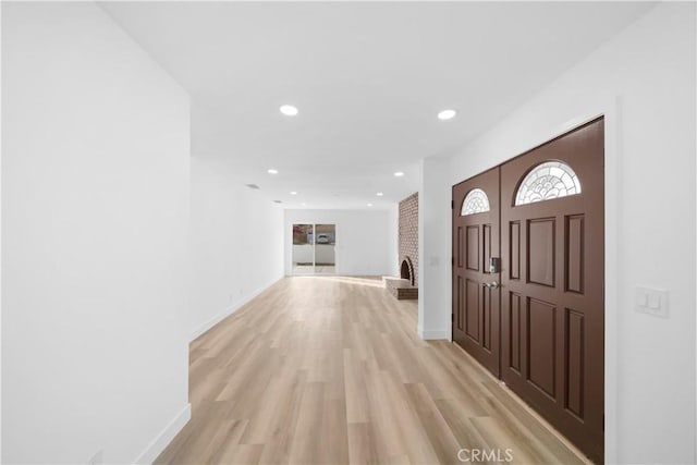 entryway featuring a fireplace and light wood-type flooring