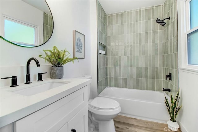 full bathroom with toilet, vanity, wood-type flooring, and tiled shower / bath