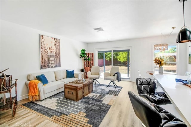 living room with a notable chandelier and light wood-type flooring