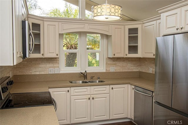 kitchen with sink, hanging light fixtures, appliances with stainless steel finishes, and white cabinets