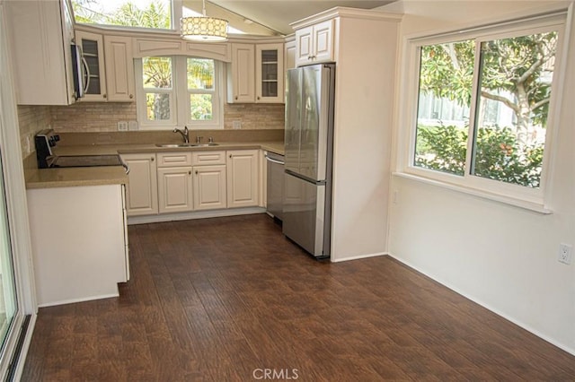 kitchen with tasteful backsplash, dark hardwood / wood-style floors, sink, white cabinetry, and stainless steel appliances