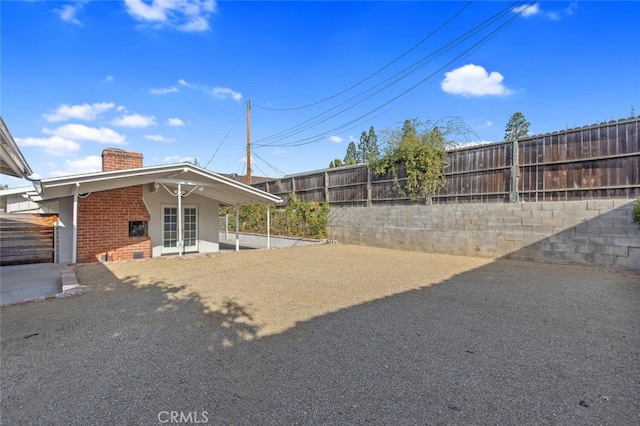 view of yard with french doors and a fenced backyard