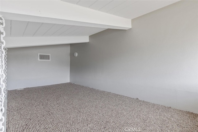 carpeted spare room with vaulted ceiling with beams and visible vents