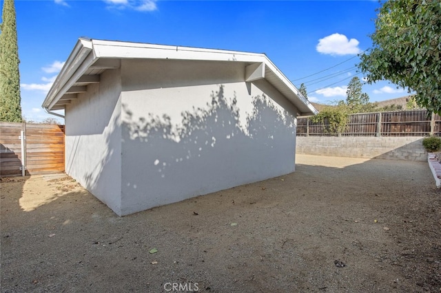view of side of home featuring stucco siding and a fenced backyard