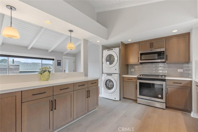 kitchen with tasteful backsplash, stacked washer / dryer, decorative light fixtures, lofted ceiling with beams, and stainless steel appliances