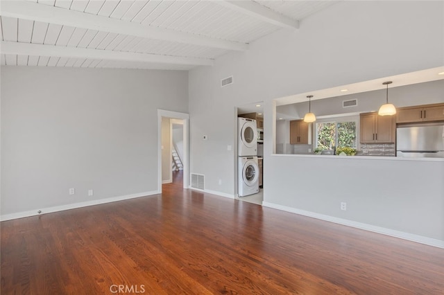 unfurnished living room with wood-type flooring, high vaulted ceiling, beamed ceiling, and stacked washer and clothes dryer