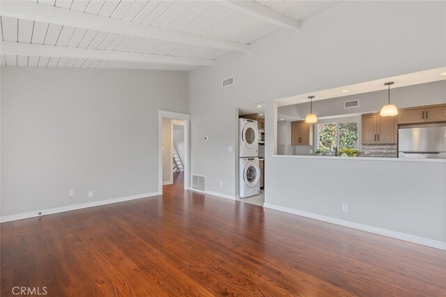 unfurnished living room with hardwood / wood-style flooring, wood ceiling, stacked washer and clothes dryer, and vaulted ceiling with beams