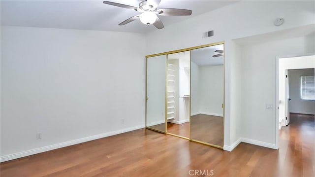 unfurnished bedroom with ceiling fan, hardwood / wood-style floors, and a closet