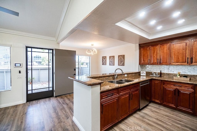 kitchen with sink, light hardwood / wood-style flooring, and kitchen peninsula